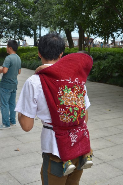 Kinder werden im Sack getragen